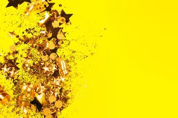 Golden sparkles on yellow background. Holiday concept.
