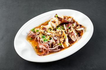 Chinese Chaoshan home cooking, a plate of oyster sauce steamed small squid on a black background