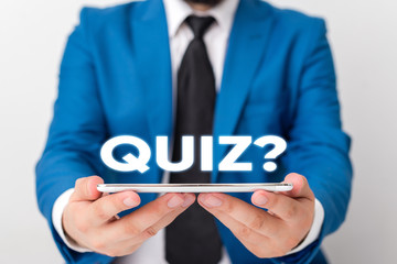 Handwriting text writing Quiz Question. Conceptual photo test of knowledge as competition between individuals or teams Businessman in blue suite with a tie holds lap top in hands