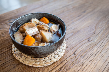 A bowl of Hericium erinaceus shark bone soup on a wooden table