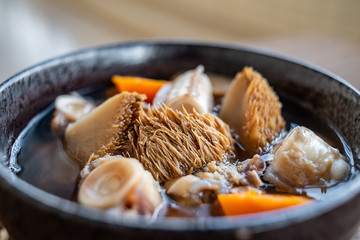 A bowl of Hericium erinaceus shark bone soup on a wooden table