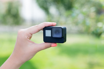 Making a selfie with action camera concept. Camera in woman hand. Close-up.