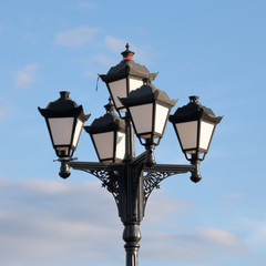 Fototapeta na wymiar Lantern in the park in vintage style. Against the background of blue sky.