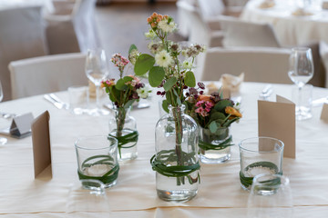 Closeup of decorated wedding tables, with flowers serviette and cutlery