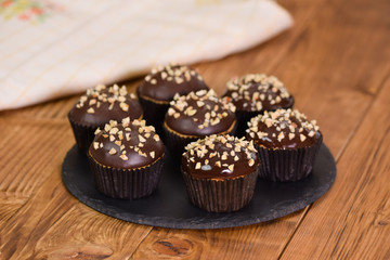 Obraz na płótnie Canvas Nut-chocolate muffins covered with dark chocolate and nuts