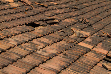 Obraz na płótnie Canvas Broken old terracotta rooftiles with hole, traditional cover in India, GOA. Close up. Textured summer background.