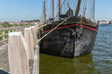 Bow sailing ship moored at pier of Dutch village Urk