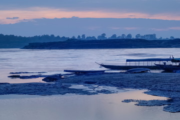 Obraz premium River view morning of long-boat floating in Mekong river with cloudy sky background, sunrise at Sam Phan Bok, attraction in Ubon Ratchathani, Thailand (Thai-Laos Border).