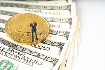 Miniature people business man standing on bitcoins coins.