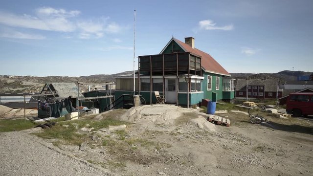 Rustic Green Nordic House in Village with Cluttered Yard and Wind Blown Clothesline - Disko Bay, Greenland