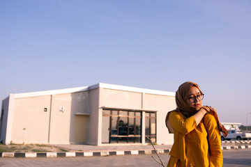Fototapeta premium fashion portrait of muslim woman with head scarf walking at outdoor parking lot