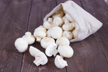 Champignon mushrooms in a bag on a dark background