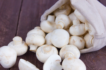 Champignon mushrooms in a bag on a dark background
