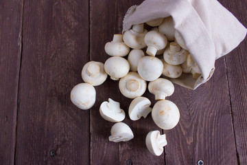 Champignon mushrooms in a bag on a dark background