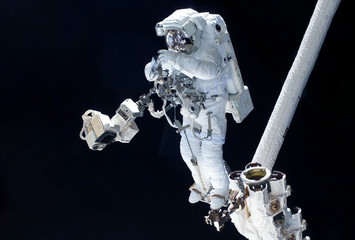 Astronaut in a spacesuit, in outer space, on a dark background. Elements of this image were...