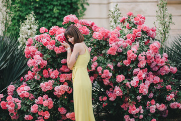 Woman beauty with tattoo on hand near roses in garden.