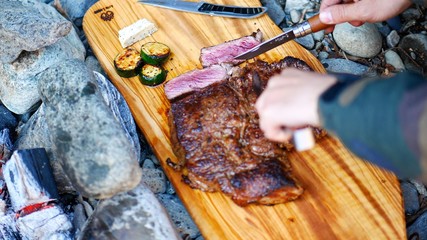 キャンプ場で焼いたステーキを切り分ける