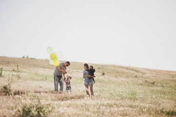 Happy family having fun on sunny meadow.