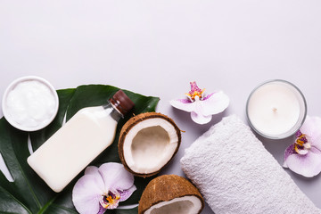 Fototapeta na wymiar Coconut cosmetic product, tropical leaves and flowers. Natural spa concept