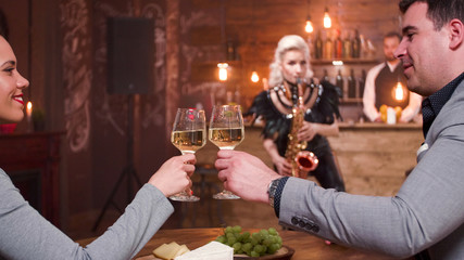 Romantic couple smiling and clinking a glass of wine