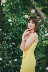 Woman beauty with tattoo on hand near roses in garden.