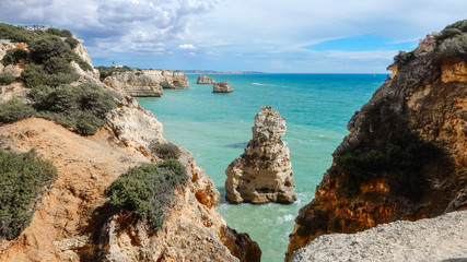 Fototapeta na wymiar Panoramic view of the Algarve ocean cliffs, Portugal, with cloudy dramatic sky