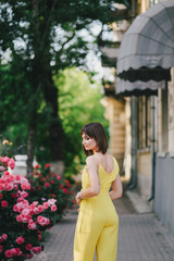 Woman beauty with tattoo on hand near roses in garden.