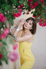 Woman beauty with tattoo on hand near roses in garden.
