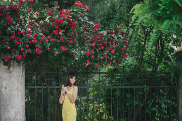 Woman beauty with tattoo on hand near roses in garden.