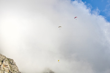 Paragliders floating in clouds over Table Mountain, Cape Town.