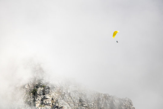 Paragliders floating in clouds over Table Mountain, Cape Town.