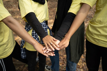 Happy volunteer stacking hands together when joining work