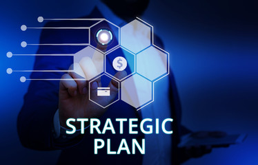 Word writing text Strategic Plan. Business photo showcasing a systematic process of envisioning a desired future Male human wear formal work suit presenting presentation using smart device