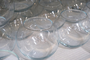 Several rows of transparent empty glass containers without lids. Bunch of vases on a shelf in a store