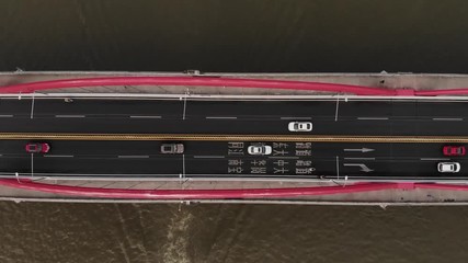 Light automotive traffic on four lanes of bridge, top-down aerial shot, camera fly up. Jiefang bridge span across Pearl River at Guangzhou. Unusual straight perspective from above