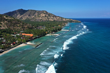 Beautiful drone view of white sand beach and a calm resorts of Candi Dasa, East Bali.