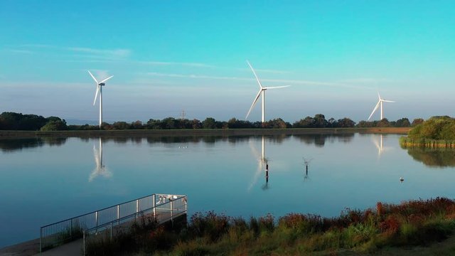 Aerial view of Pen-y-fan pond in Blackwood, Wales UK which has 3 wind turbines nearby