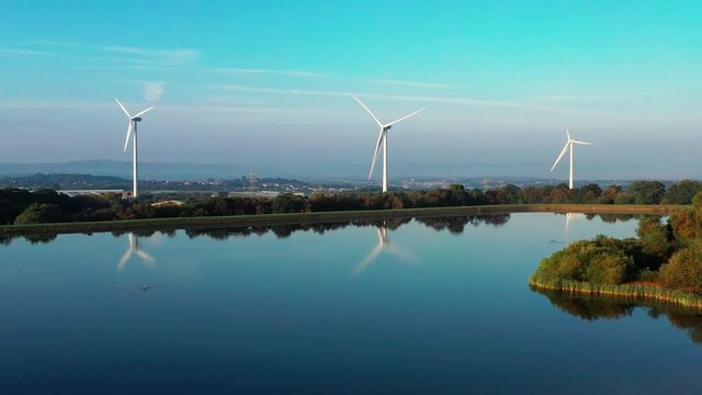Aerial view of Pen-y-fan pond in Blackwood, Wales UK which has 3 wind turbines nearby