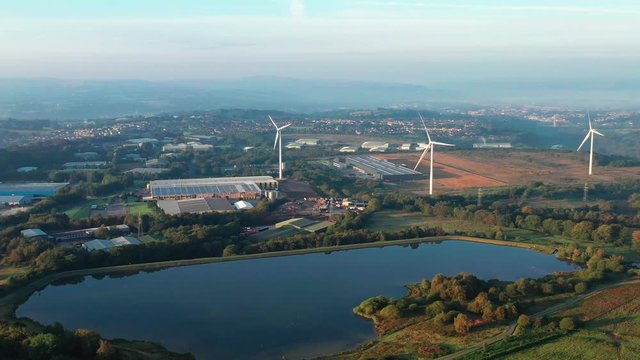 Aerial view of Pen-y-fan pond in Blackwood, Wales UK which has 3 wind turbines nearby