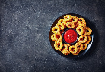 crispy calamari rings on a black plate