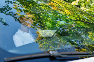 Beautiful smiling brunette girl behind the wheel of a car