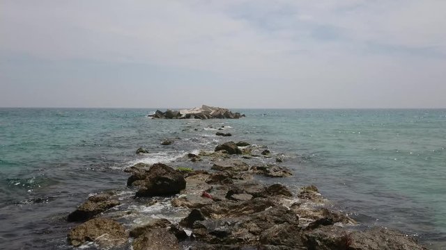 Relaxing waves on mediterranean sea with rocks and stones