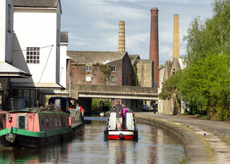 A pleasure boat on the Leeds & Liverpool canal making its way through the industrial heart of...