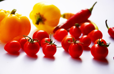 fresh tomatoes and peppers on a white background