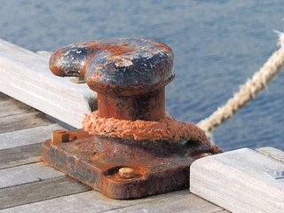 Weathered mooring bollard with ships rope