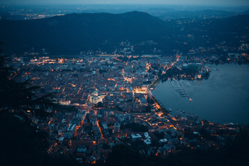 Fototapeta premium Top view of the night city of Como, Italy. Mountains, port and bay.