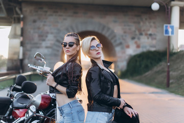 Sexy gorgeous young women outdoors with motorcycle on road. Friendship, beauty, sexy lady, transportation concept