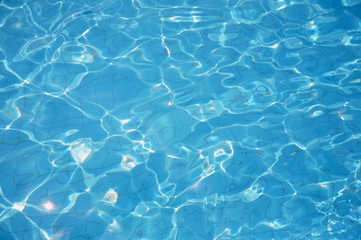 Fototapeta na wymiar Swimming pool bottom caustics ripple and flow with waves background. Summer background. Texture of water surface.