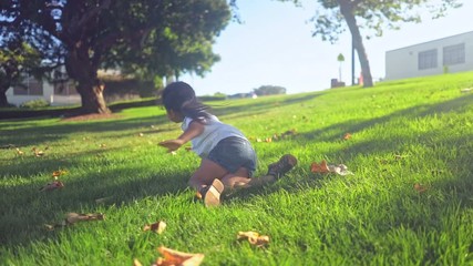 Young Girl Rolling Down a Grassy Hill - Powered by Adobe