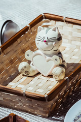 Figurine statuette de chat roux à rayure posée sur une corbeille en osier